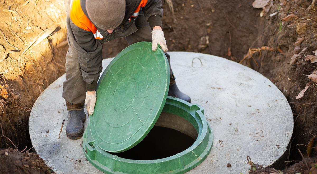 man opening septic lid